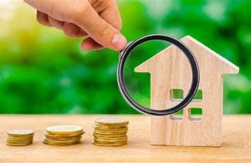 A miniature house with three stacks of coins