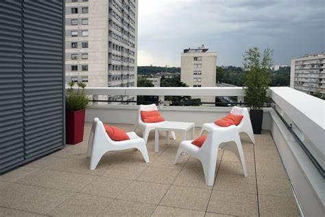 Un petit balcon avec quatre chaises  